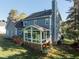 Back exterior view showcasing a screened-in porch and a well-maintained yard at 5812 N Beaver Ln, Raleigh, NC 27604