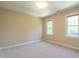 Neutral bedroom with natural light from two windows, featuring plush carpeting and ample space at 5812 N Beaver Ln, Raleigh, NC 27604