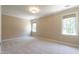 Bright bedroom features neutral walls and carpet, two windows, and a modern ceiling light at 5812 N Beaver Ln, Raleigh, NC 27604