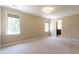 This beige bedroom is bright with two windows and has an open door to a private bathroom at 5812 N Beaver Ln, Raleigh, NC 27604