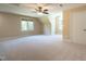 A very large bedroom, carpeted in light beige, is illuminated with three windows and a ceiling fan at 5812 N Beaver Ln, Raleigh, NC 27604