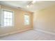 Sunlit bedroom featuring neutral carpet and walls, two windows offering natural light at 5812 N Beaver Ln, Raleigh, NC 27604