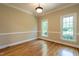 An empty room with hardwood floors, neutral paint, and windows providing ample natural light at 5812 N Beaver Ln, Raleigh, NC 27604