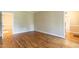 Spacious empty room with hardwood floors, neutral walls, and well-defined trim at 5812 N Beaver Ln, Raleigh, NC 27604