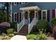 Inviting front porch with steps and manicured landscaping and a decorated front door at 5812 N Beaver Ln, Raleigh, NC 27604