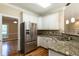 Kitchen featuring stainless steel refrigerator, granite countertops, and ample storage at 5812 N Beaver Ln, Raleigh, NC 27604