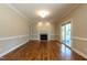Open living room with fireplace, hardwood floors, and access to outdoor screened porch at 5812 N Beaver Ln, Raleigh, NC 27604