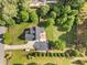 An aerial view shows a gray home with long driveway and detached garage with a patio in the back at 6200 Oliver Creek Pkwy, Holly Springs, NC 27540