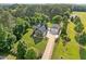 An aerial view of a gray home with a two-car garage and long driveway on a large lot at 6200 Oliver Creek Pkwy, Holly Springs, NC 27540