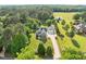 An aerial view of a gray home with a two-car garage and long driveway on a large lot at 6200 Oliver Creek Pkwy, Holly Springs, NC 27540