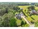 An aerial view of a gray home with a two-car garage and long driveway on a large lot at 6200 Oliver Creek Pkwy, Holly Springs, NC 27540