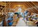 Unfinished attic space with exposed beams and a window; ample storage potential at 6200 Oliver Creek Pkwy, Holly Springs, NC 27540