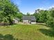 Beautiful backyard showcasing the home, patio, screened porch, and lush greenery at 6200 Oliver Creek Pkwy, Holly Springs, NC 27540