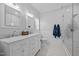 Bright bathroom features a double vanity with marble countertop and a glass-enclosed shower at 6200 Oliver Creek Pkwy, Holly Springs, NC 27540