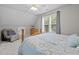 Cozy bedroom with a comfy chair, wooden bed frame, and a window view at 6200 Oliver Creek Pkwy, Holly Springs, NC 27540