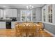 Charming dining area with a modern chandelier, natural light, and view of the lush backyard at 6200 Oliver Creek Pkwy, Holly Springs, NC 27540