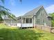 Charming home exterior with a screened porch, inviting outdoor living, and landscaped yard at 6200 Oliver Creek Pkwy, Holly Springs, NC 27540