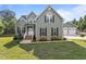 Inviting two-story home with a classic facade, landscaped front yard, and detached two-car garage at 6200 Oliver Creek Pkwy, Holly Springs, NC 27540