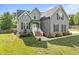 Beautiful two-story home with a well-manicured lawn, brick accents, and a welcoming front porch at 6200 Oliver Creek Pkwy, Holly Springs, NC 27540
