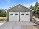 A two-car garage features carriage doors, exterior lighting, and a concrete driveway at 6200 Oliver Creek Pkwy, Holly Springs, NC 27540