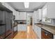 Bright kitchen with white cabinets, granite countertops, stainless appliances, and hardwood flooring at 6200 Oliver Creek Pkwy, Holly Springs, NC 27540