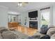Cozy living room with hardwood floors, a fireplace with TV, and access to the patio at 6200 Oliver Creek Pkwy, Holly Springs, NC 27540