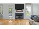 Bright living room with hardwood floors, a fireplace with TV, and backyard view at 6200 Oliver Creek Pkwy, Holly Springs, NC 27540