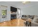 Comfortable living room features hardwood floors, a fireplace with TV, and access to the patio at 6200 Oliver Creek Pkwy, Holly Springs, NC 27540