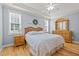 Cozy main bedroom featuring hardwood floors, a ceiling fan, and natural lighting at 6200 Oliver Creek Pkwy, Holly Springs, NC 27540