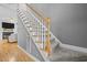 Carpeted staircase with white railings and wooden banister, leading to the upper level at 6200 Oliver Creek Pkwy, Holly Springs, NC 27540