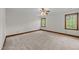 Bedroom featuring neutral colors, carpet, and two windows with natural light at 6420 Dresden Ln, Raleigh, NC 27612