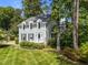 View of a charming two-story home with light-green siding and dormer windows surrounded by mature trees at 6420 Dresden Ln, Raleigh, NC 27612