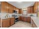 Well-lit kitchen featuring wood cabinets, stainless steel appliances, granite countertops, and tile flooring at 6420 Dresden Ln, Raleigh, NC 27612