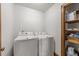 Bright laundry area with washer, dryer, and storage shelving at 6420 Dresden Ln, Raleigh, NC 27612