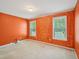 A bedroom with orange accent wall and two windows dressed with blinds at 649 Flaherty Ave, Wake Forest, NC 27587