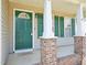 Welcoming covered front porch with a green door and brick accents at 649 Flaherty Ave, Wake Forest, NC 27587