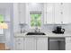 This Kitchen has stainless steel appliances, white cabinets and is brightly lit by a window at 6612 Rossford Ln, Durham, NC 27713