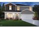 Charming two-story home with gray siding, a covered front porch, and a two-car garage at 676 White Birch Ln, Angier, NC 27501