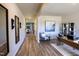 Hallway with wood flooring leading to a home office and dining room with modern light fixtures, mirrors, and decor at 712 Deschutes Dr, Garner, NC 27529