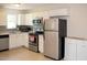 Well-lit kitchen featuring white cabinetry, stainless steel appliances, and practical tile flooring at 7177 Sandy Creek Dr, Raleigh, NC 27615