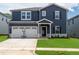 Charming two-story home featuring blue siding, white trim, and an attached two-car garage at 749 Deschutes Dr, Garner, NC 27529