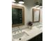 Bathroom showcasing double sinks, framed mirrors, and a view into the shower with green tile at 7501 Tipsy Sq, Wake Forest, NC 27587