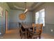 Elegant dining room with wainscoting, decorative wall art, and a modern chandelier above a rustic wooden table at 7501 Tipsy Sq, Wake Forest, NC 27587