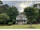Charming two-story home with a stone and vinyl facade, surrounded by mature trees and lush landscaping at 7501 Tipsy Sq, Wake Forest, NC 27587