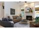 Cozy living room with a stone fireplace, stylish furnishings, and ample natural light from large windows at 7501 Tipsy Sq, Wake Forest, NC 27587