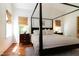 Charming main bedroom with hardwood floors, windows, and a large four-poster bed at 7501 Tipsy Sq, Wake Forest, NC 27587