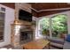 Inviting sunroom boasts a stone fireplace, TV, wood ceiling and serene outdoor views at 7501 Tipsy Sq, Wake Forest, NC 27587