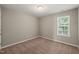 Bedroom features neutral walls, carpet, a window with blinds, and an overhead light fixture at 8253 Martello Ln, Raleigh, NC 27613