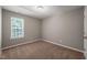 A bedroom with neutral walls, carpet flooring, a window with blinds, and natural light at 8253 Martello Ln, Raleigh, NC 27613