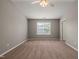 Well-lit bedroom with neutral carpet, a ceiling fan, and a window allowing for natural light and ventilation at 8253 Martello Ln, Raleigh, NC 27613